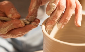 Hands working on pottery wheel , retro style